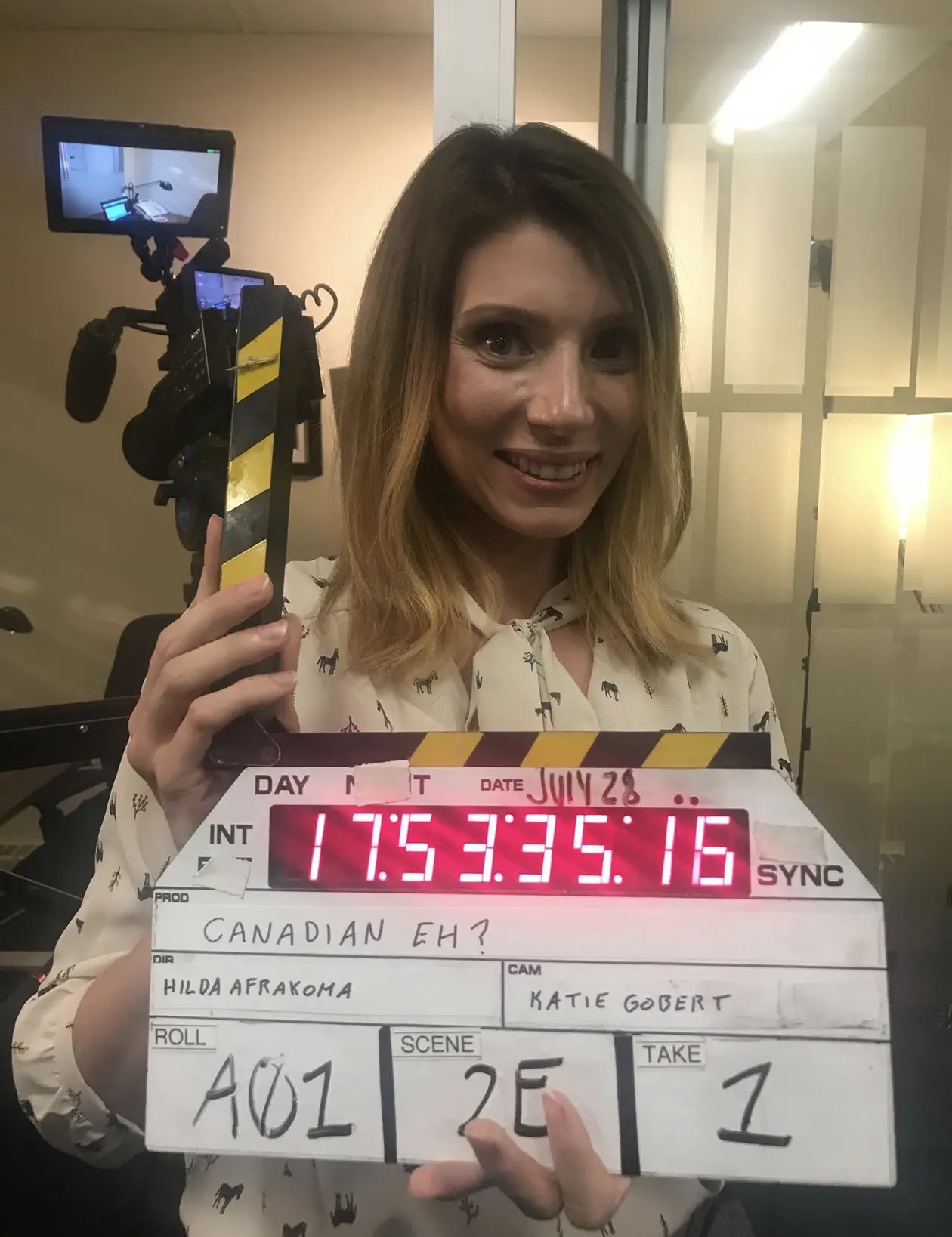 Rae-Ann on a film set holding a clapperboard